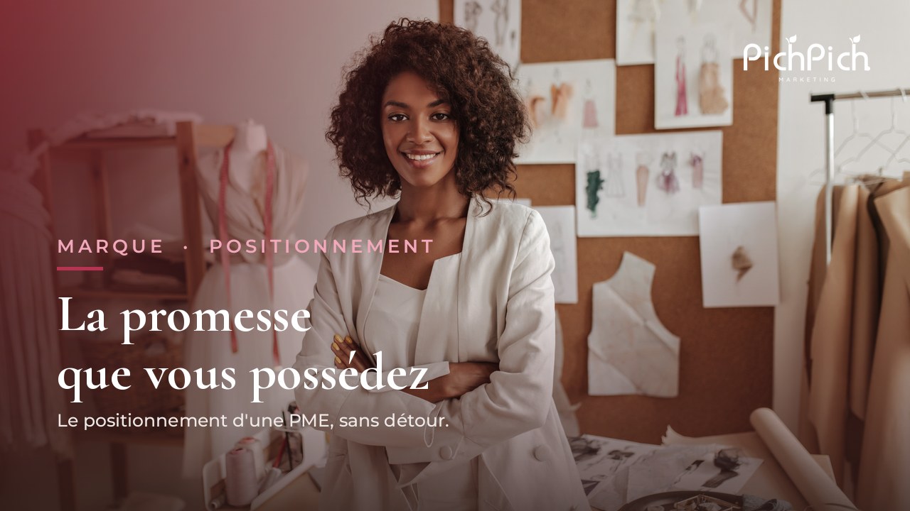 Fondatrice de petite entreprise souriante, bras croisés, debout dans son atelier de création devant ses croquis