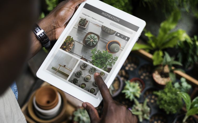Propriétaire de petite entreprise qui répond à un appel de client en prenant des notes devant son ordinateur portable
